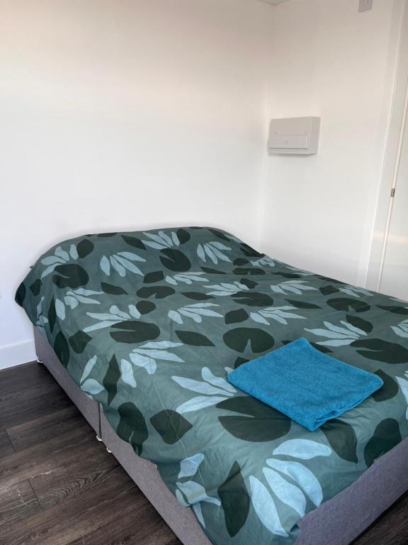 Cama en habitación con colcha de camuflaje en The Serviced Accommodations, en Harlow