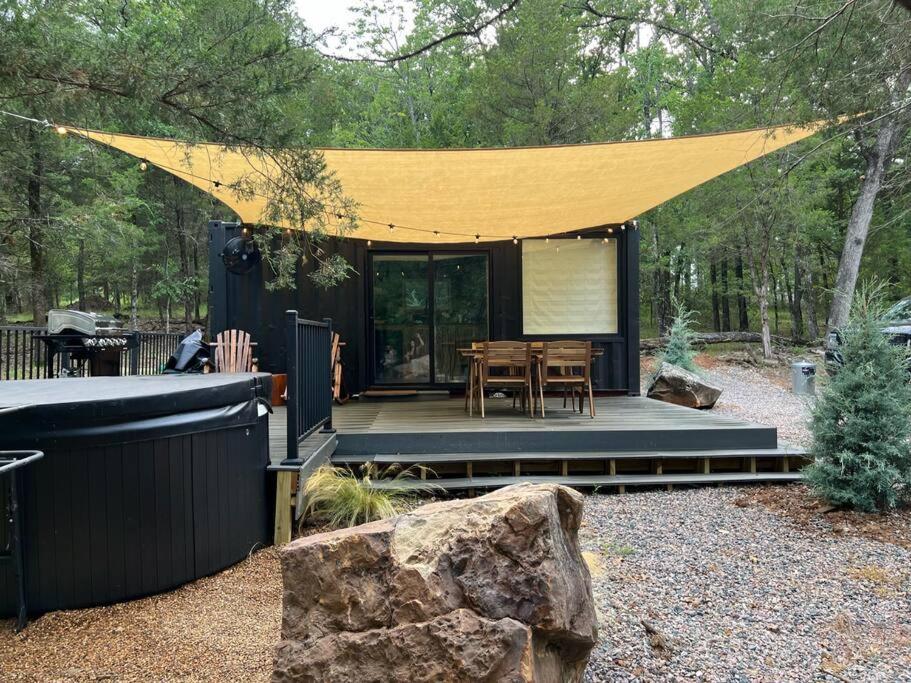 een kleine hut met een tafel en een gele tent bij HiddenAcres Cabin - woodsy private couples retreat in Eustace