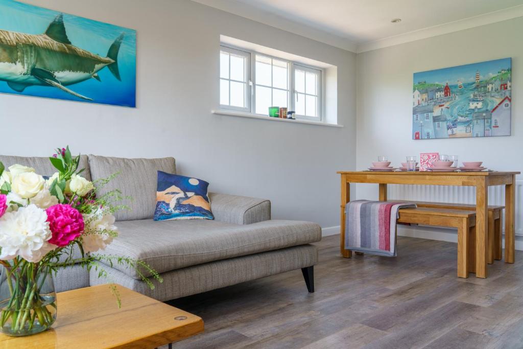 uma sala de estar com um sofá e uma mesa em Spacious & charming apartment by the New Forest em Ringwood
