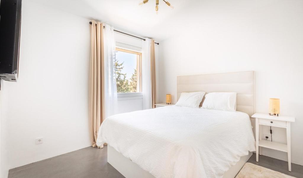 a white bedroom with a white bed and a window at Apartment Puerto Banus Marbella in Marbella