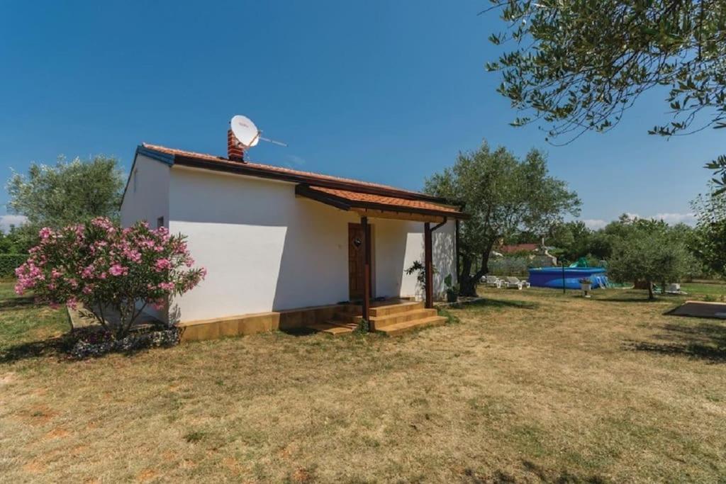 a small white house with a roof at Holiday Home Lovric in Filipac