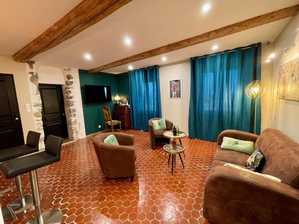 - un salon avec des rideaux bleus, un canapé et des chaises dans l'établissement Détente parfumée, capitale du parfum, à Grasse