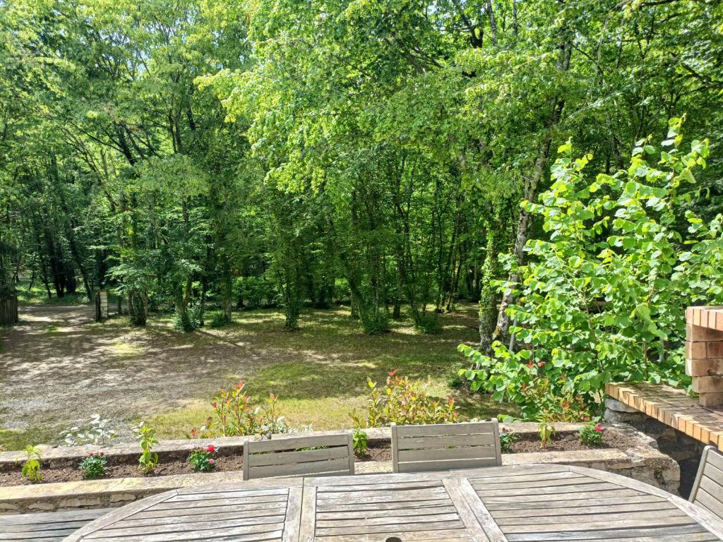 two chairs sitting on a table in a garden at La maison du bois, 10 minutes de l'A71, 10 minutes de Bourges in Plaimpied-Givaudins