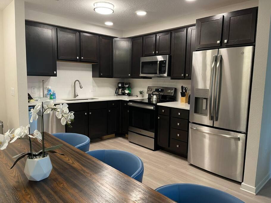 a kitchen with a wooden table and stainless steel appliances at Vista Cay Condo, next to convention center, See World, Disney 3 in Orlando