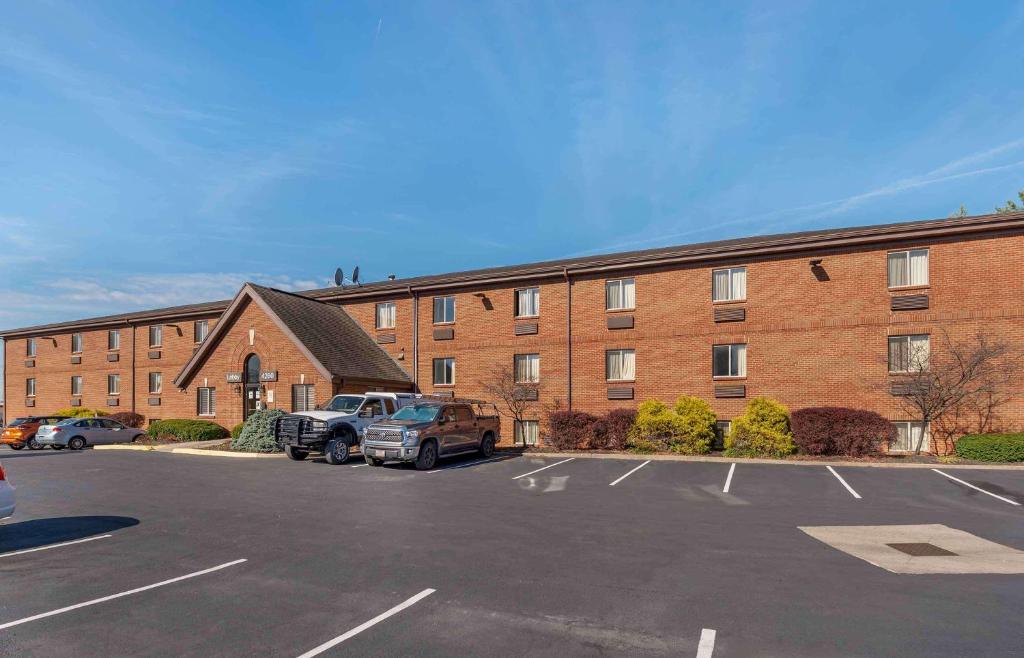 a large brick building with a truck parked in a parking lot at Extended Stay America Suites - Cincinnati - Blue Ash - Reagan Hwy in Blue Ash
