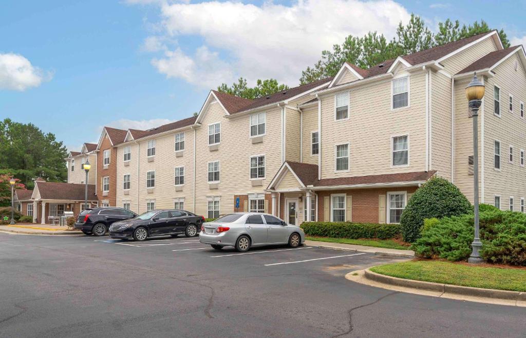 ein großes Apartmenthaus mit Autos auf einem Parkplatz in der Unterkunft Extended Stay America Suites - Atlanta - Norcross - Peachtree Corners in Norcross