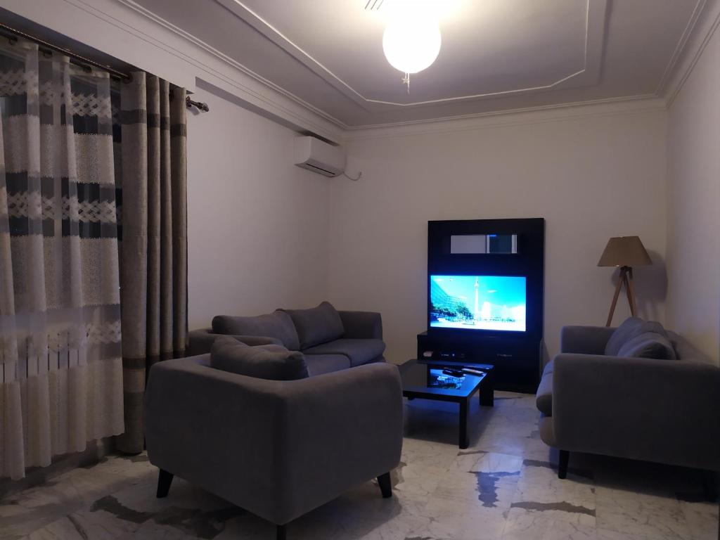 a living room with two couches and a flat screen tv at Appartement à louer à Tlemcen in Tlemcen