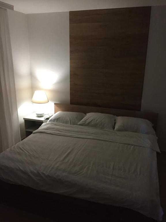 sypialnia z dużym białym łóżkiem i lampką w obiekcie Apartman B&B w mieście Pale