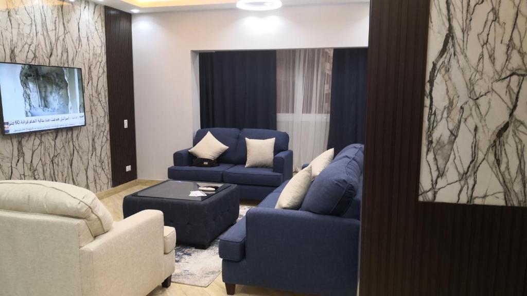 a living room with two blue chairs and a couch at Alhejaz Luxurious Apartment in Cairo
