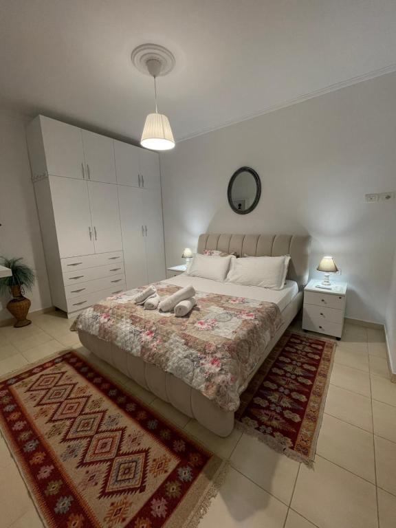 1 dormitorio con 1 cama grande y 1 alfombra en Meg’s Apartment, en Gjirokastra