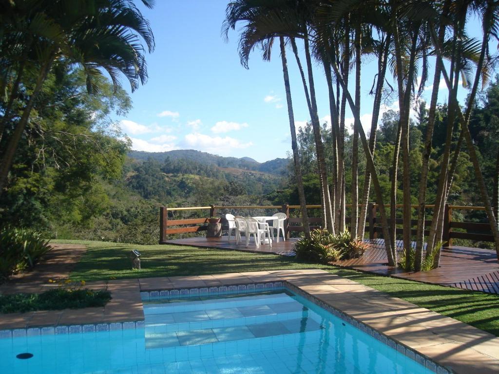 a swimming pool in a yard with a table and chairs at Terracota Hotel in Itaipava
