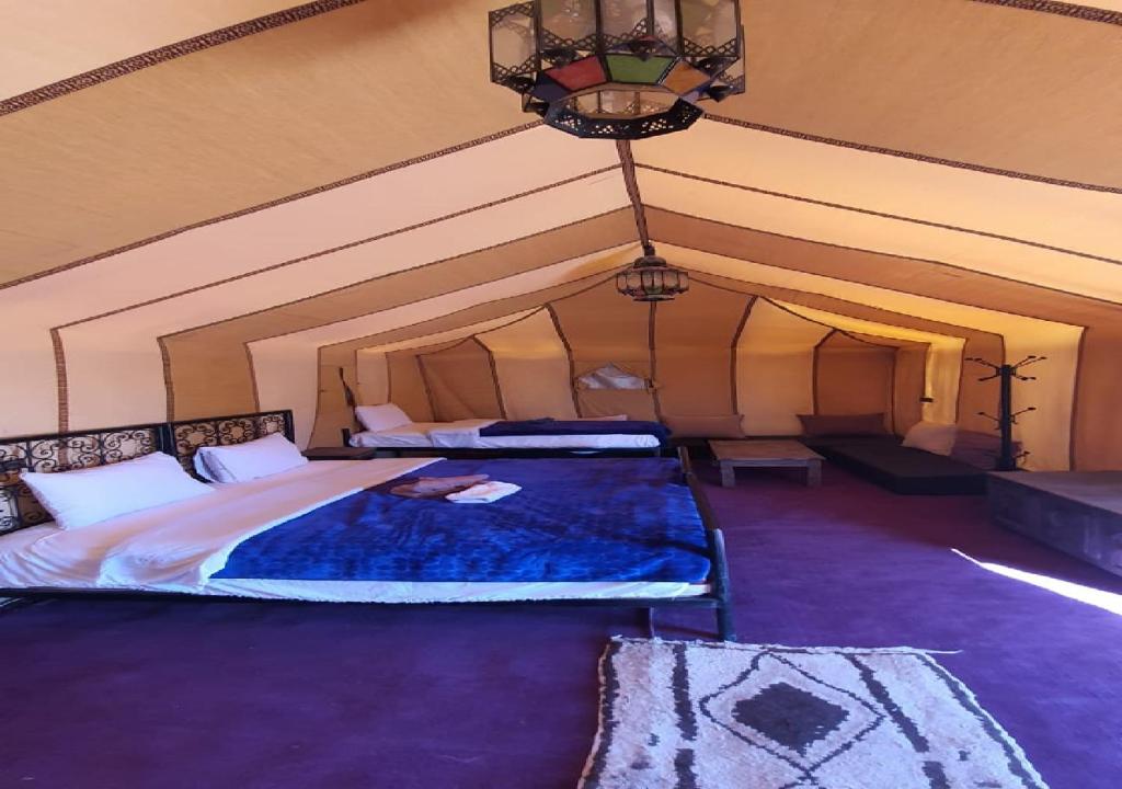 a bedroom with a large bed in a tent at Luxury Desert Romantic Camp in Merzouga