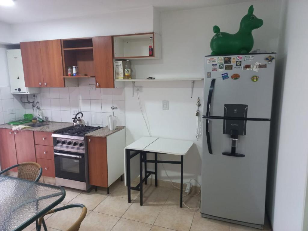 a kitchen with a white refrigerator and a table at Depto Luminoso 1 Dormitorio para 2 con Patio in Rosario