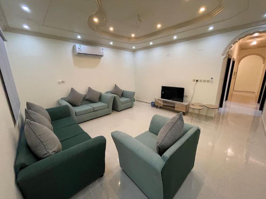 a living room with two couches and a television at شقة واسعة بفناء خاص و دخول ذاتي in Al Madinah