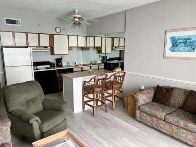 a kitchen and a living room with a couch and chairs at ROYAL GARDEN RESORT 1510 condo in Myrtle Beach