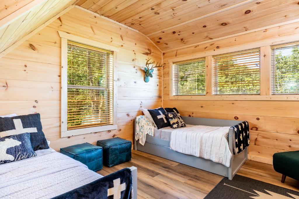 a bedroom with two beds in a log cabin at Cloudchaser Cabin, Private, New Cabin, 2 Kings, Cozy, Modern, Hot Tub, View, Theater in Sevierville