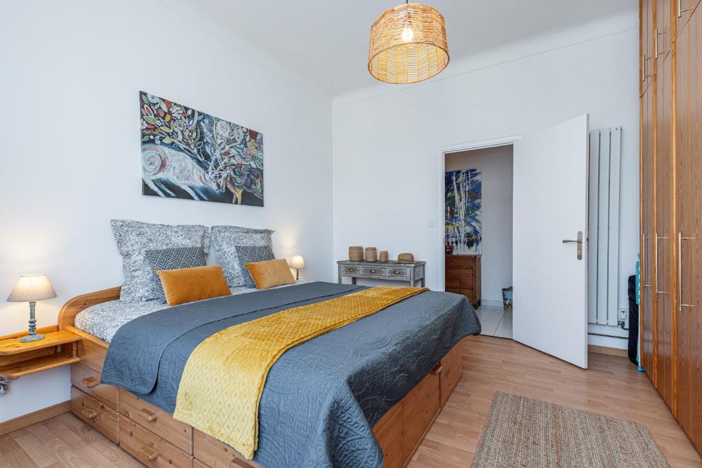 - une chambre dotée d'un lit avec une couverture bleue et jaune dans l'établissement The place to be in Nice, à Nice