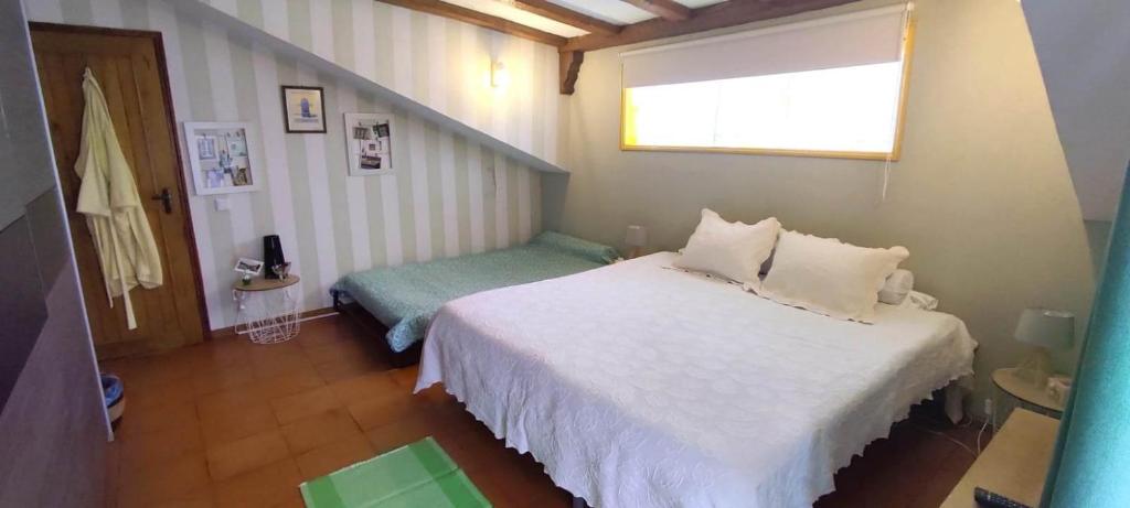 um quarto com uma cama branca e uma janela em Casa Amarela em Esmoriz