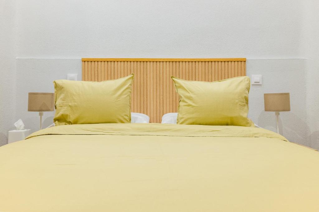 - un grand lit avec 2 oreillers jaunes dans l'établissement CENTRICO APARTAMENTO CON 3 BAÑOS EN PUERTA DEL SOL y ATOCHA, à Madrid
