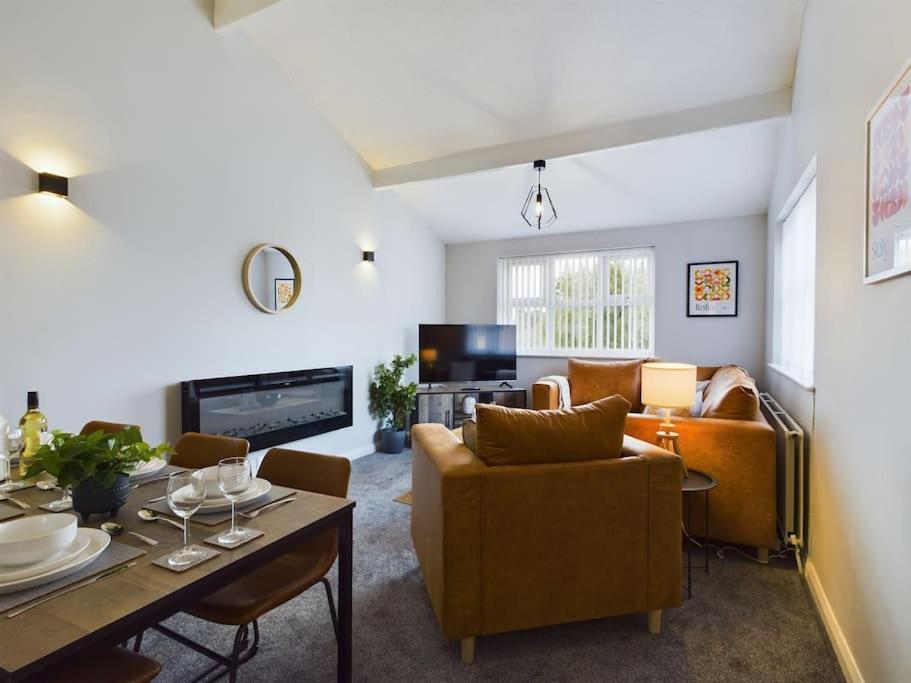 uma sala de estar com um sofá e uma mesa em Luxury Accommodation with TVs in each Room em Macclesfield
