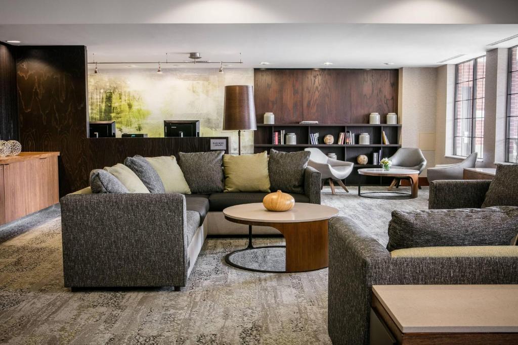 a living room with two couches and a table at Courtyard by Marriott Omaha Aksarben Village in Omaha