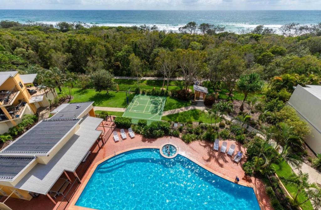- une vue aérienne sur un complexe avec une piscine et un court de tennis dans l'établissement Marcoola Beach Resort, à Marcoola