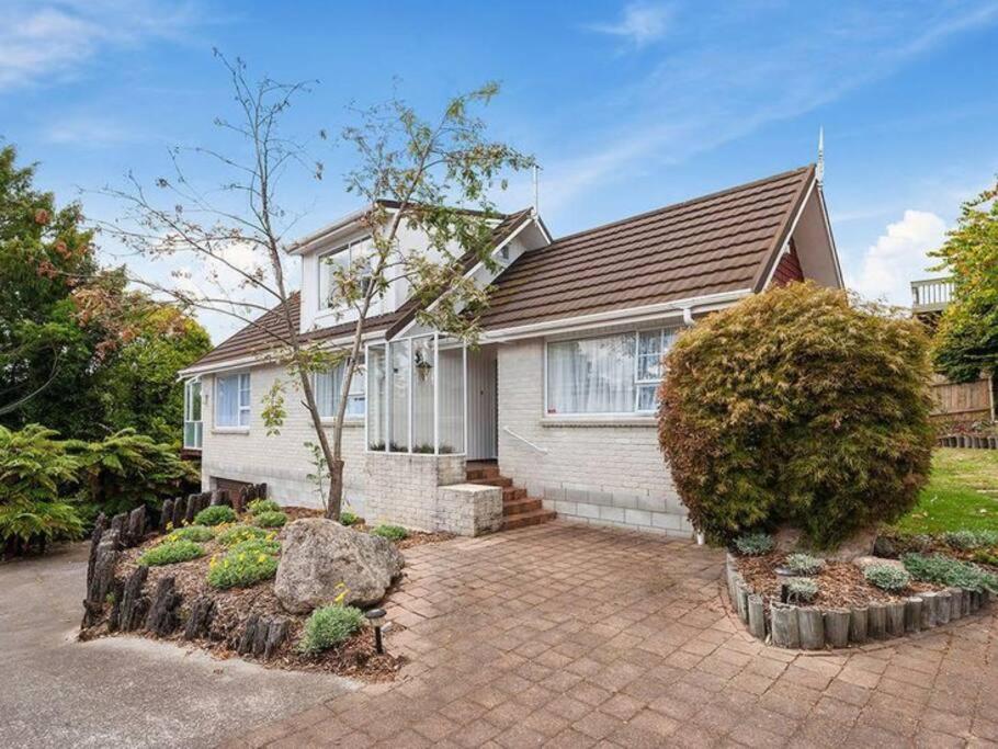 a house with a brick driveway in front of it at Charming Hideaway in Taupo