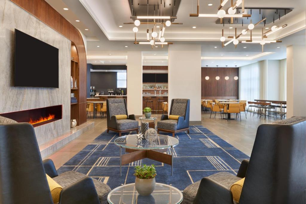 a lobby with chairs tables and a fireplace at Courtyard by Marriott Kitchener in Kitchener