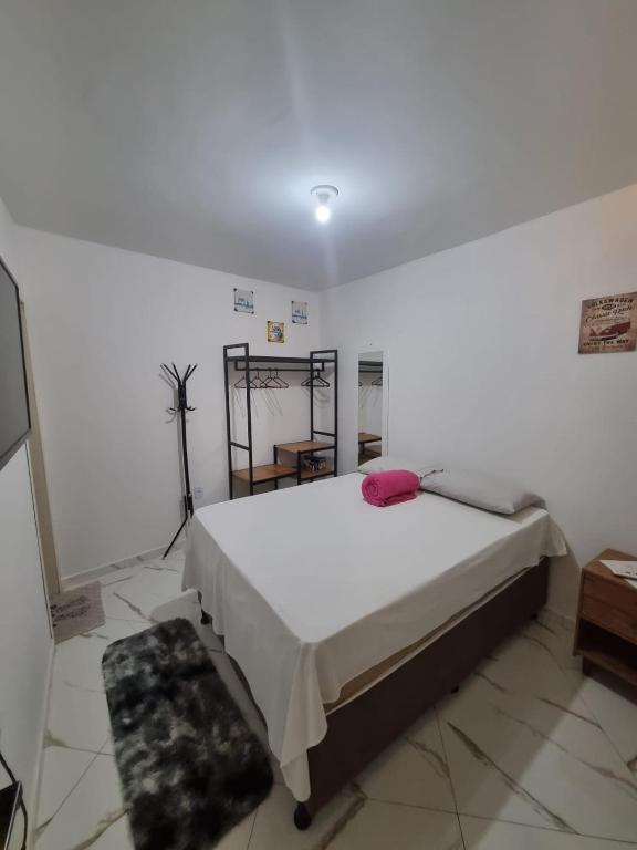 een slaapkamer met een groot bed in een witte kamer bij kitnet encantadora no centro de Campina Grande -PB - APT 302 in Campina Grande