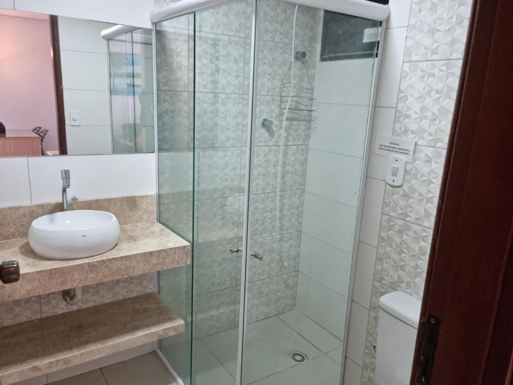 ein Bad mit einer Glasdusche und einem Waschbecken in der Unterkunft Excelente apartamento na praia de ponta verde in Maceió