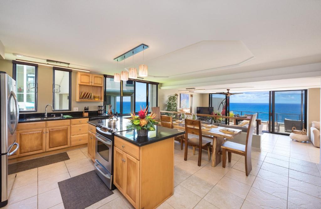 uma cozinha e sala de jantar com vista para o oceano em Puu Poa Ocean Bluff Condo, Incredible Views, Walk to Beaches, Pool & Tennis em Princeville