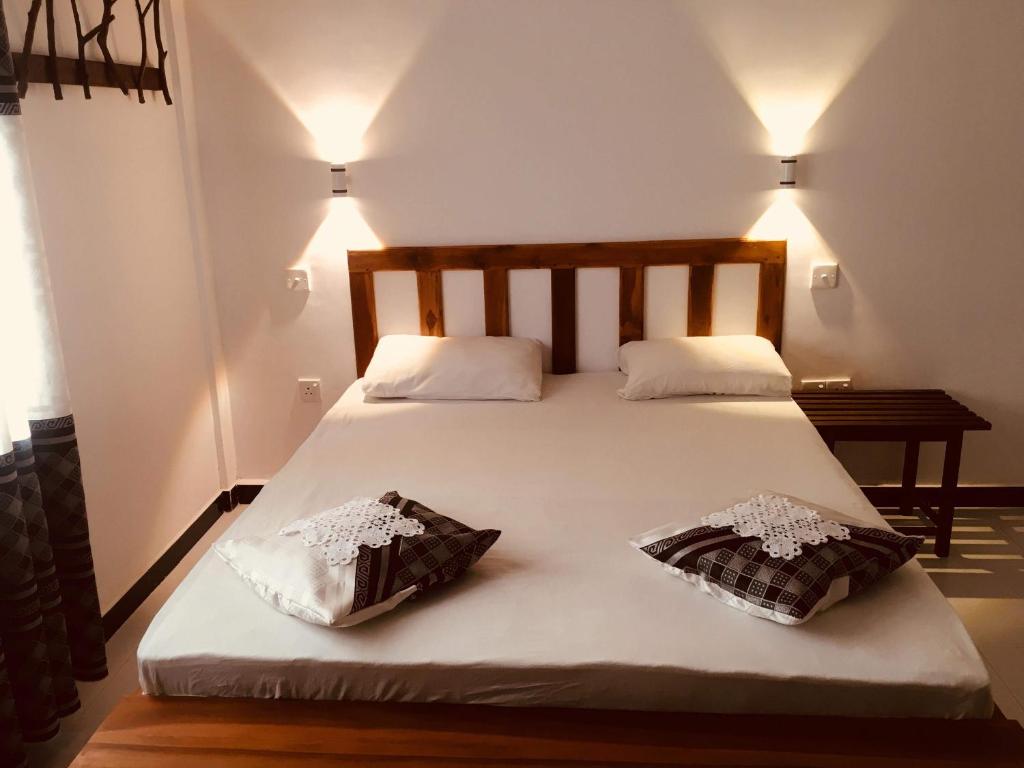a large white bed with two pillows on it at Wild Eagle Safari Resort in Udawalawe