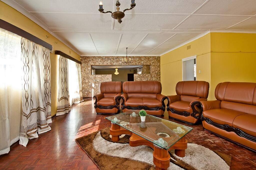 a living room with leather furniture and a table at MACUM's Haven in Roodepoort