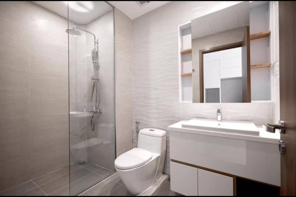 y baño con aseo, lavabo y ducha. en A sea view beautiful studio apartment, en Nha Trang