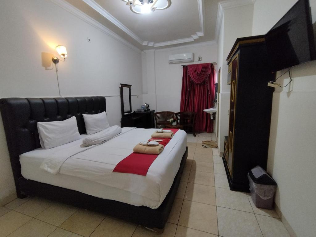 um quarto com uma cama grande e um cobertor vermelho e branco em SPOT ON 92695 My Kost Syariah 