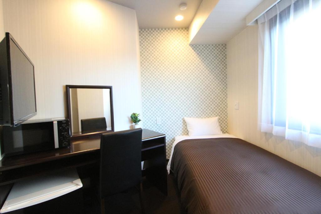 Postel nebo postele na pokoji v ubytování HOTEL LiVEMAX Nihonbashi Hakozaki