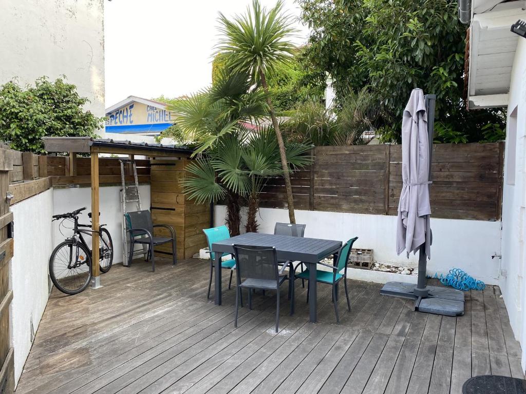 een patio met een tafel en stoelen en een parasol bij Appartement Arcachon, 3 pièces, 4 personnes - FR-1-474-249 in Arcachon