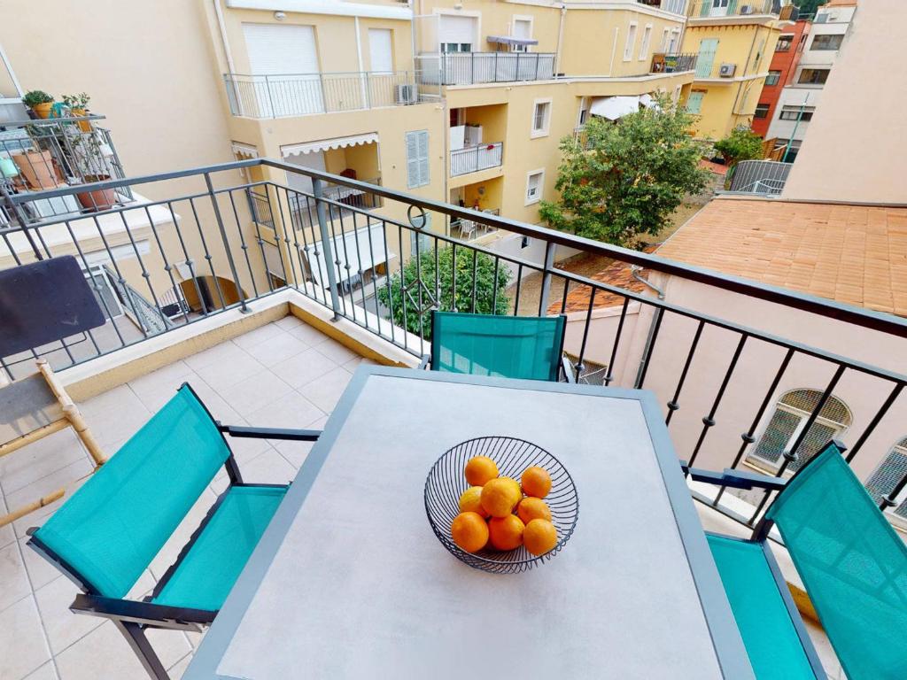 a bowl of oranges on a table on a balcony at Appartement Menton, 2 pièces, 4 personnes - FR-1-196-336 in Menton