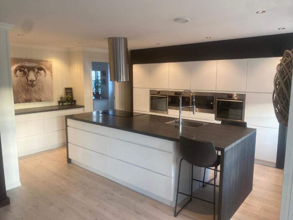 a kitchen with a large island with a black counter top at Stort luftig hus i Fredrikstad in Fredrikstad