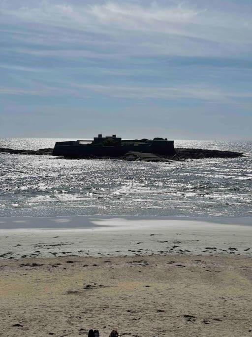 une île dans l'océan avec un navire dans l'eau dans l'établissement STUDIO VUE MER LE FORT BLOQUE PLOEMEUR, à Ploemeur