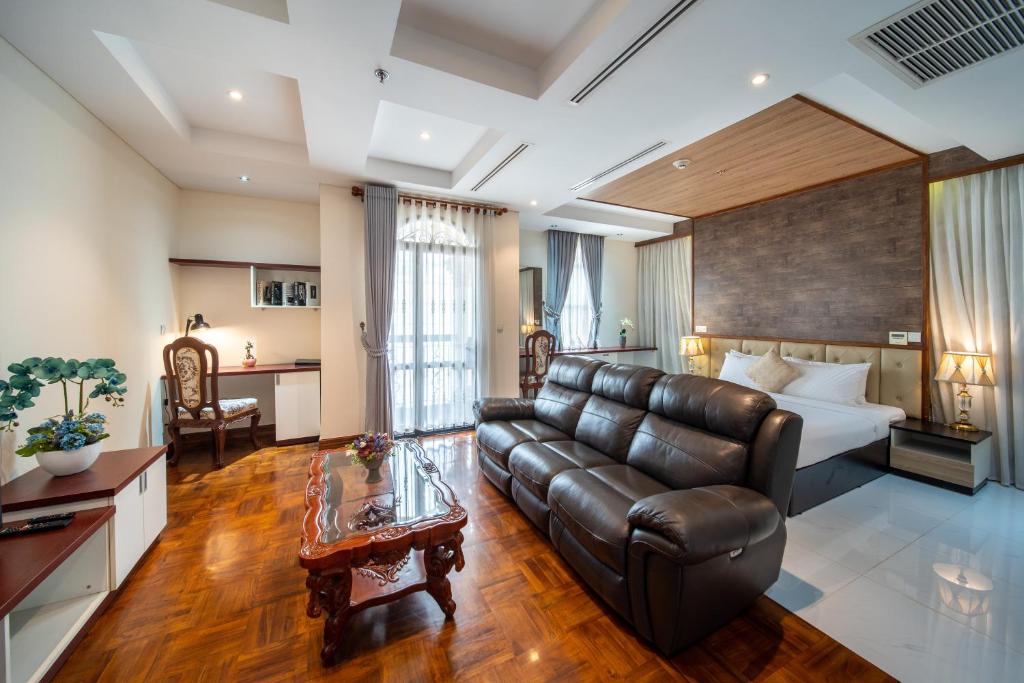 a living room with a couch and a bed at LCS Hotel & Apartment in Phnom Penh