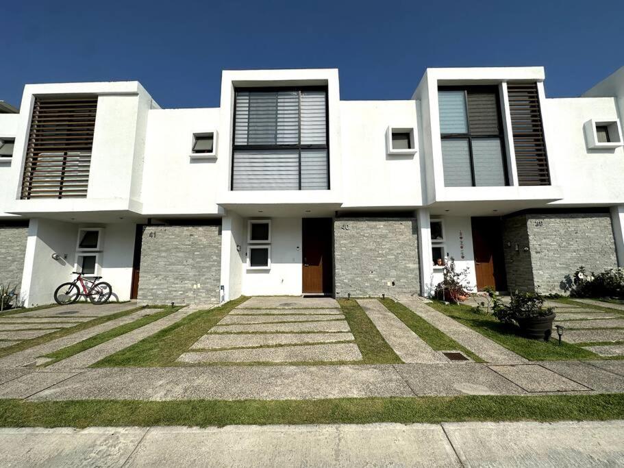una gran casa blanca con una entrada delante de ella en Modern Beautiful Condo, en Mezcales