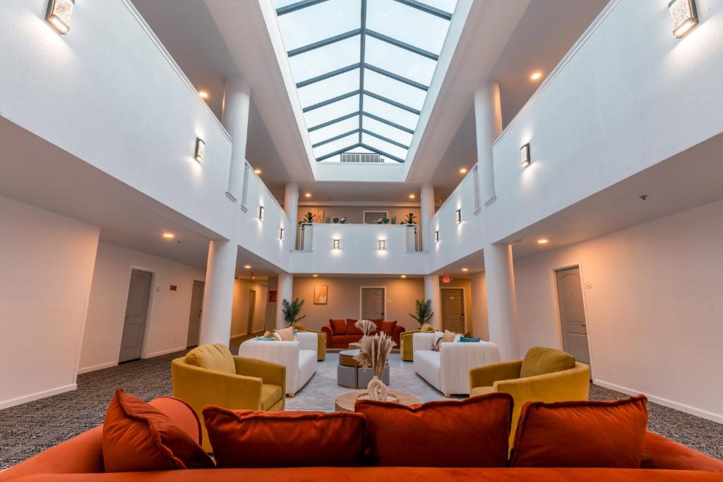 a large lobby with couches and chairs and a skylight at Hotel Aluxor SFO, Shuttle Service in San Bruno