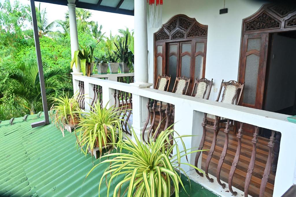 une terrasse couverte avec des chaises et des plantes sur une maison dans l'établissement Vindiw Holiday Resort, à Anurâdhapura