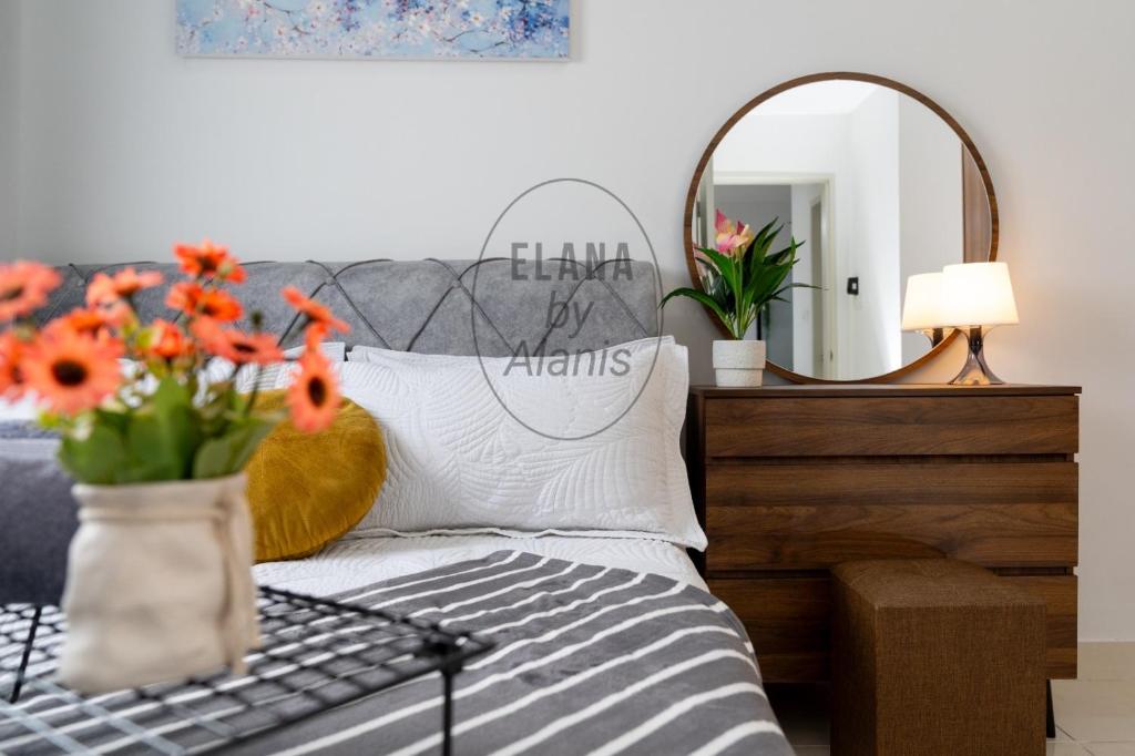 雪邦Elana by Alanis Free Wifi and Netflix的花瓶和镜子的床