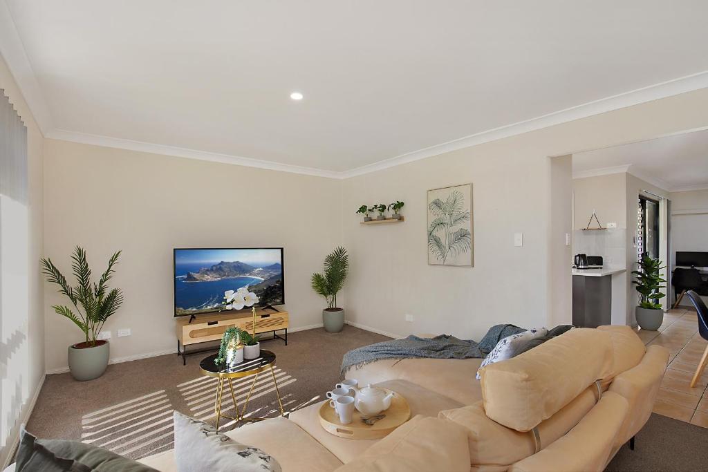 sala de estar con sofá y TV de pantalla plana en Terbium Sanctuary, en Brisbane