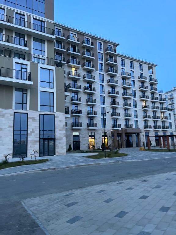 una calle vacía frente a un gran edificio de apartamentos en Aktau Reviera 1 ком апартамент en Ömirzaq