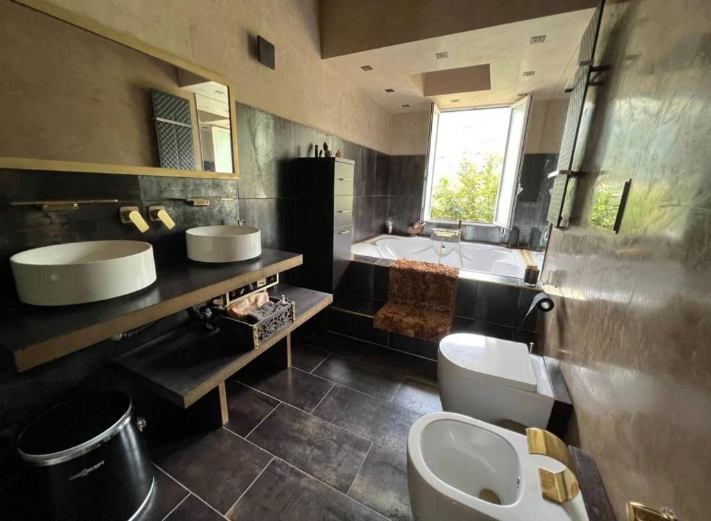 y baño con 2 lavabos, aseo y bañera. en HOME GREEN, en San Bernardo