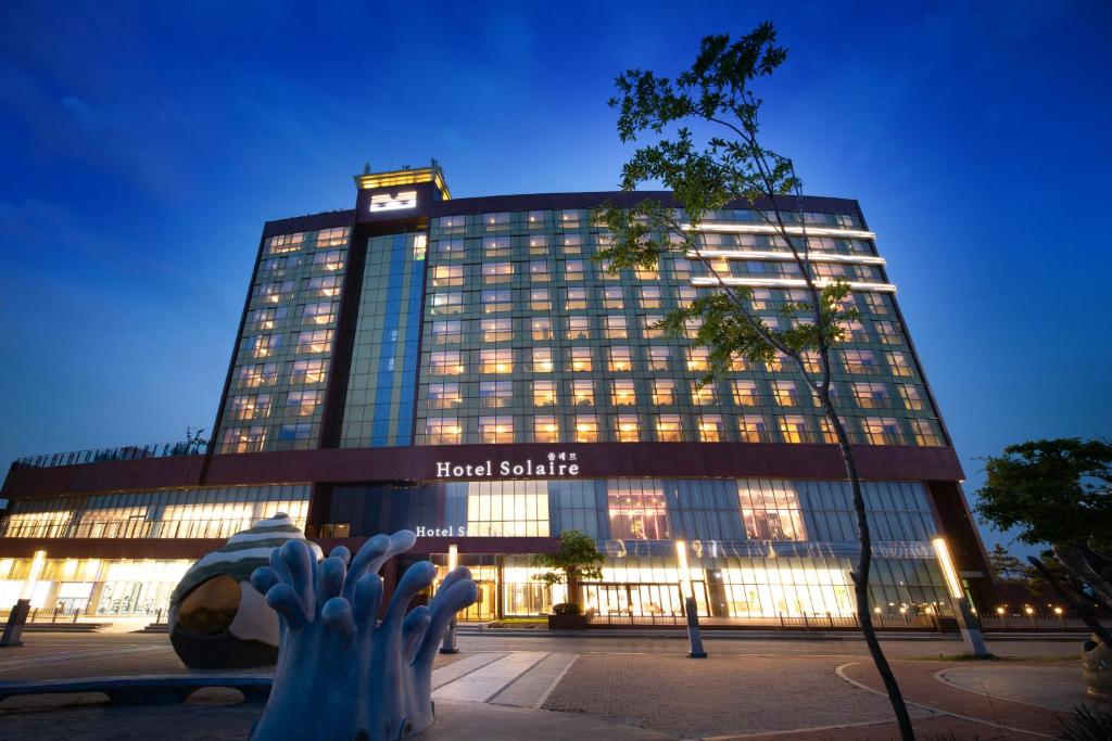 um edifício de hotel com um relógio em cima em Hotel solaire em Boryeong