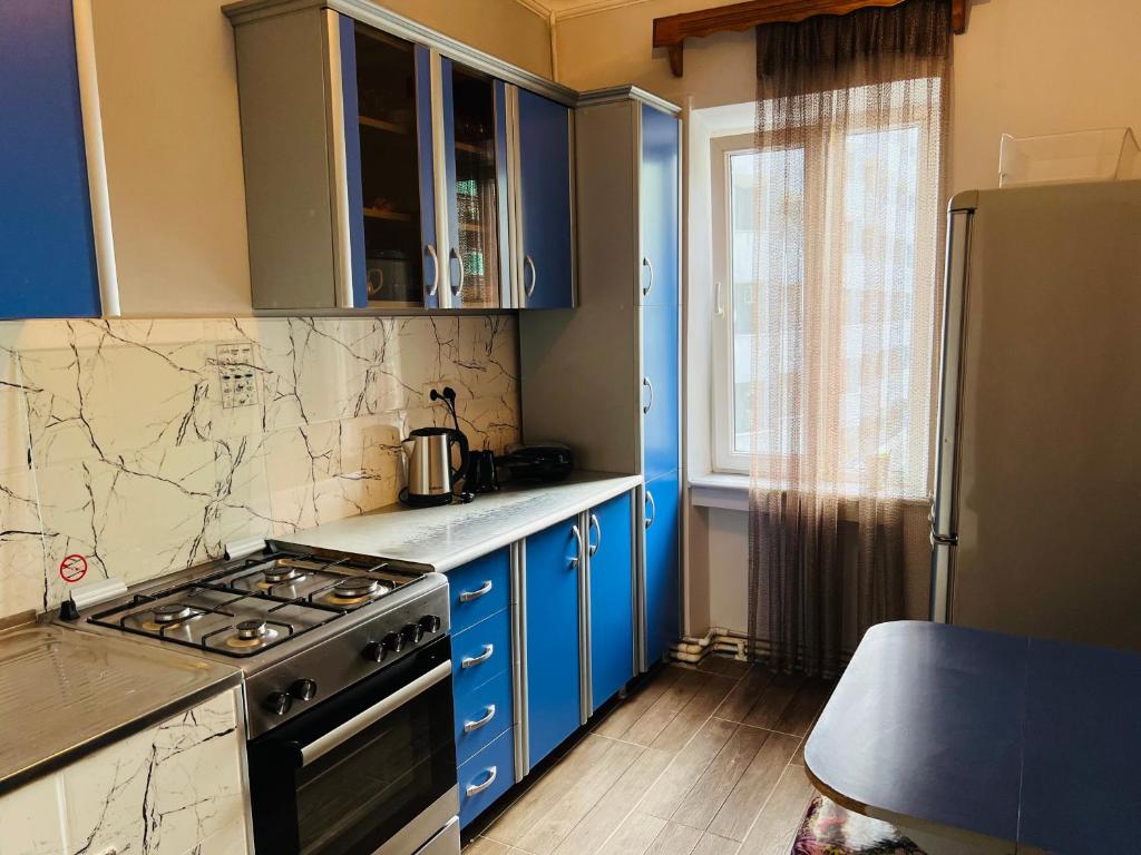 a kitchen with blue cabinets and a stove at holiday apartment in Batumi
